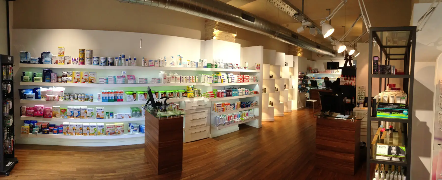 Mostradores de madera y estanterías iluminadas en el interior de la farmacia.